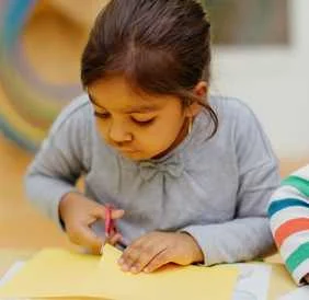 Child practising fine-motor cutting